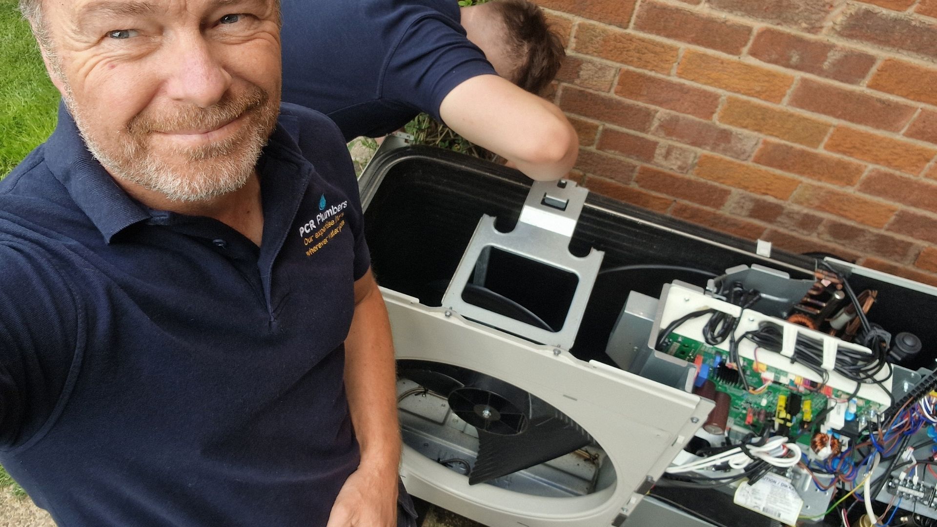 Air-source heat pump service and repair by PCR Plumbers in Cawood, serving rural homes across Selby, YO8 and YO19 PCR Plumbers engineer servicing an open air-source heat pump unit at a home in Cawood, near Selby