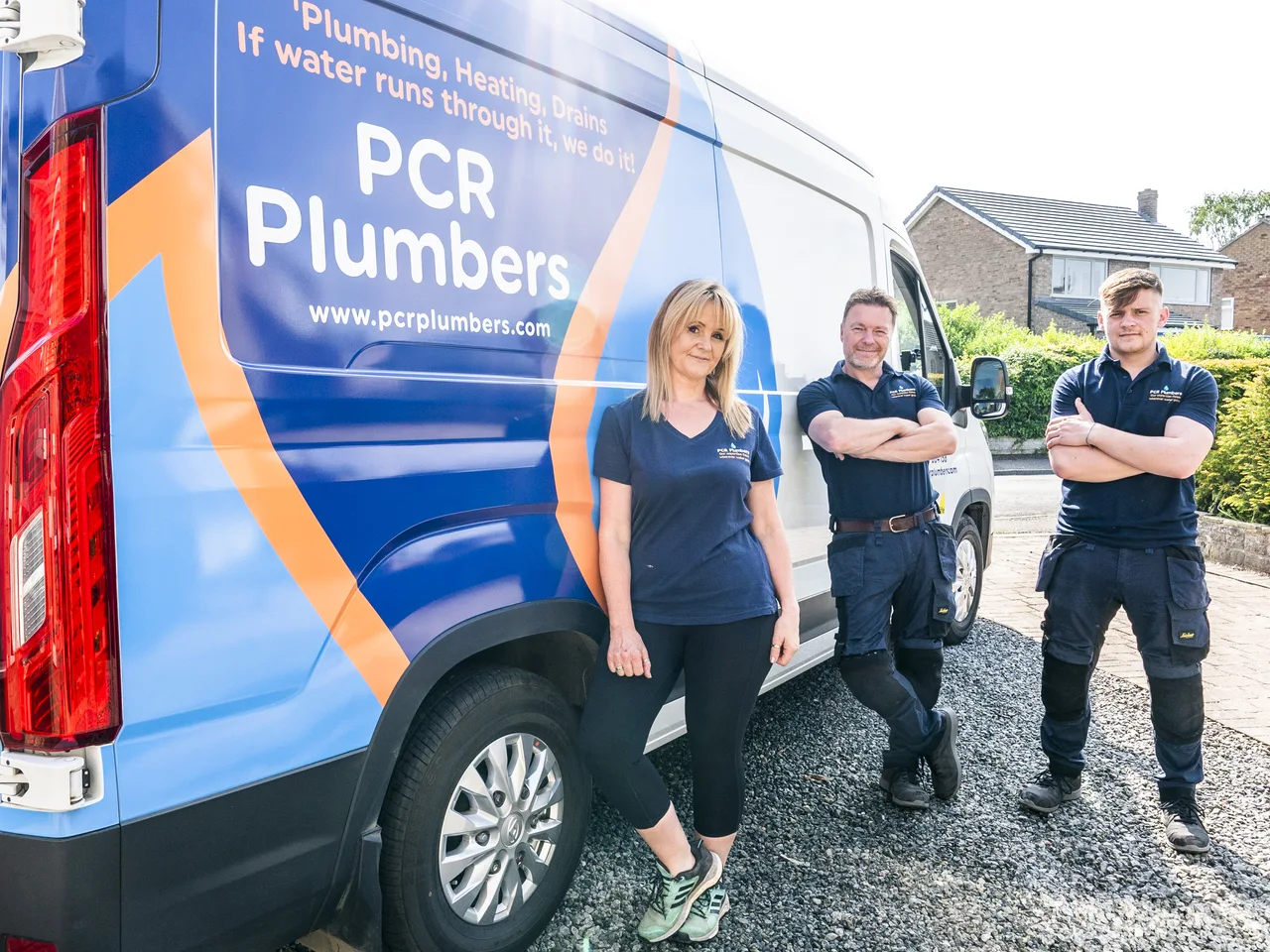 Three members of the PCR team beside their branded van