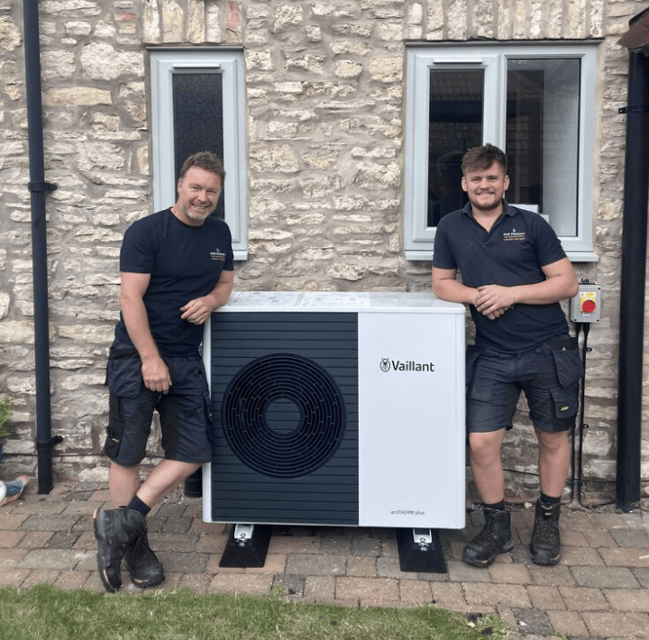 Heat Pump Installation from Certified Heat Geek heat pump installers standing proudly in front of a newly installed heat pump unit in the UK